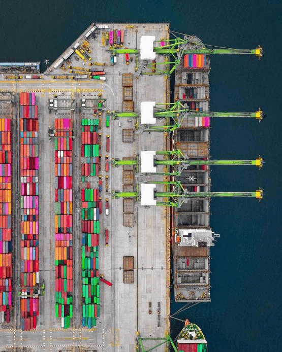 Aerial view of a U.S. container port with cargo cranes and shipping containers during customs clearance process