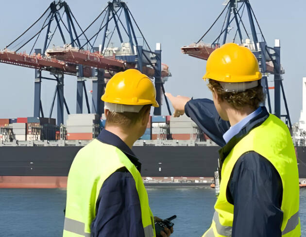 Port workers coordinating FCL shipping container operations at terminal