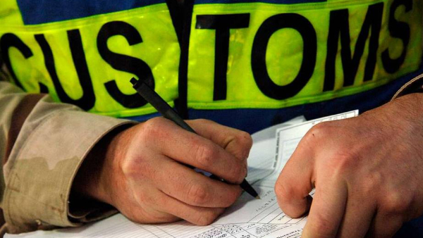 Customs officer inspecting documents for vape cross-border shipment and clearance procedures